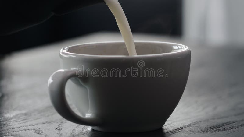 Slow motion pour steamed milk into white cup making cappuccino with copy space stock video footage