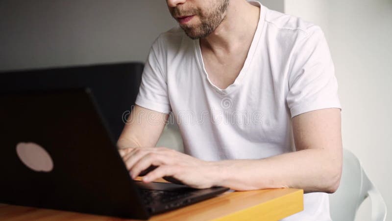 Slow motion video. Young man using laptop. Guy hands typing at computer keyboard