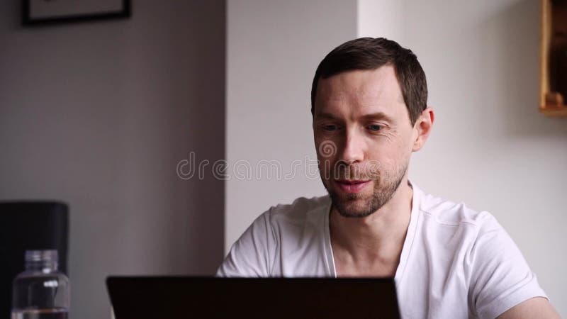 Slow motion video. Young man using laptop. Guy hands typing at computer keyboard