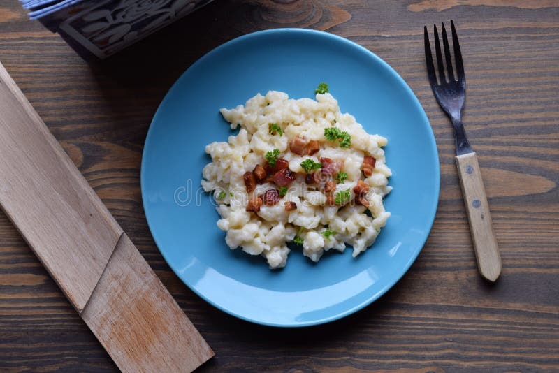 Slowaakse traditionele aardappelgnocchi met schapenkaas en bacon, houten lijst stock afbeeldingen Slowaakse traditionele aardappelgnocchi met schapenkaas en bacon, houten lijst stock afbeeldingen