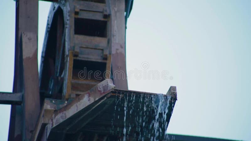 Sluit een prachtig uitzicht op een watermolen of een waterwiel dat het water spint en duwt