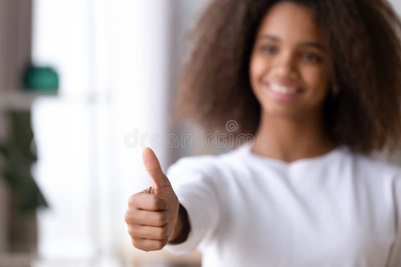 Smiling African American teenage girl showing thumbs up, like, satisfied black teenager recommending something, satisfied by education course or online service, good news, hand close up. Smiling African American teenage girl showing thumbs up, like, satisfied black teenager recommending something, satisfied by education course or online service, good news, hand close up