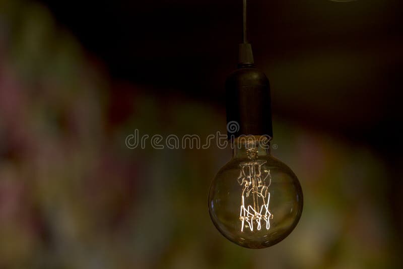 Sluit omhoog beeld van een stoffige retro stijl elektrische gloeilamp die een zwak licht in een donker binnenland verstrekken royalty-vrije stock foto's Sluit omhoog beeld van een stoffige retro stijl elektrische gloeilamp die een zwak licht in een donker binnenland verstrekken royalty-vrije stock foto's