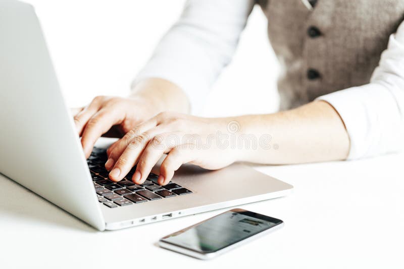 Sluit omhoog beeld van zakenman gebruikend laptop en een smartphone royalty-vrije stock foto's Sluit omhoog beeld van zakenman gebruikend laptop en een smartphone royalty-vrije stock foto's
