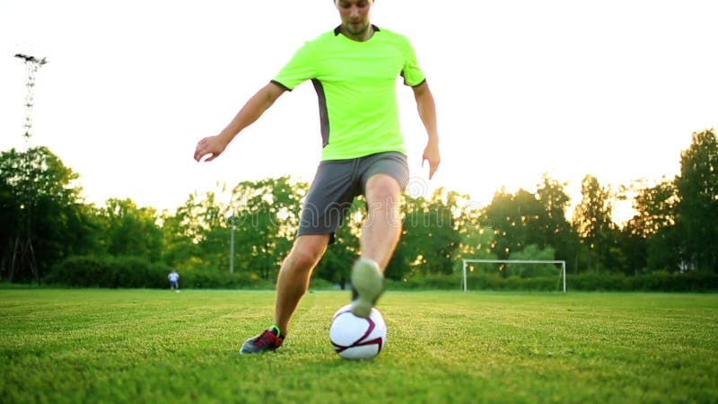 Sluit omhoog benen en voeten van voetbalster die in actie zwarte schoenen dragen die en met de bal lopen druppelen die spelen