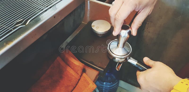 Sluit omhoog de hand van barista gebruikend stamperhulpmiddel en molen om espressoschot te maken stock afbeelding Sluit omhoog de hand van barista gebruikend stamperhulpmiddel en molen om espressoschot te maken stock afbeelding
