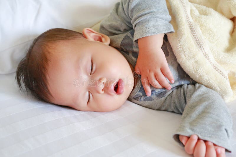 Sluit omhoog de jongensslaap van de zuigelingsbaby op bed met de deken royalty-vrije stock afbeeldingen Sluit omhoog de jongensslaap van de zuigelingsbaby op bed met de deken royalty-vrije stock afbeeldingen