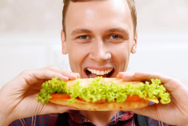 Sluit omhoog de mens die beet van sandwich nemen stock foto's Sluit omhoog de mens die beet van sandwich nemen stock foto's