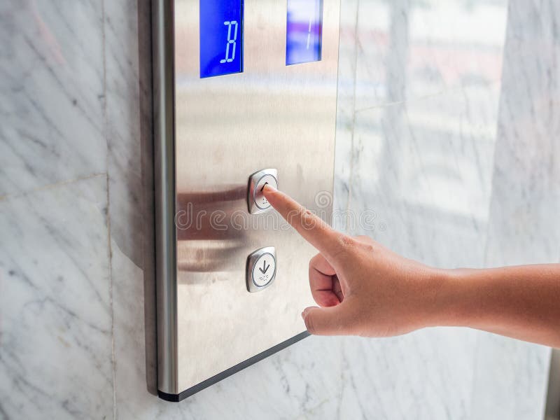 Sluit omhoog de pers van de mensenhand een omhooggaande knoop van lift binnen de bouwstijl royalty-vrije stock afbeelding Sluit omhoog de pers van de mensenhand een omhooggaande knoop van lift binnen de bouwstijl royalty-vrije stock afbeelding