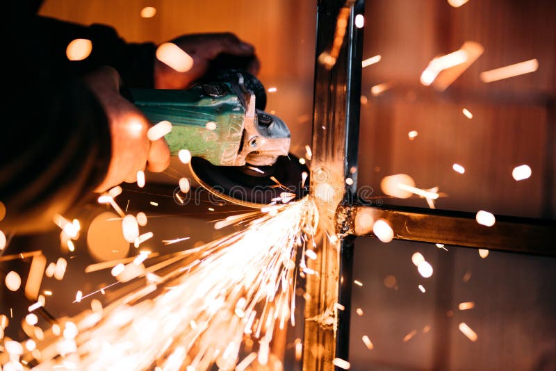 Sluit omhoog details van vonken, fabrieksarbeider gebruikend hoekmolen en scherp staal stock afbeelding Sluit omhoog details van vonken, fabrieksarbeider gebruikend hoekmolen en scherp staal stock afbeelding