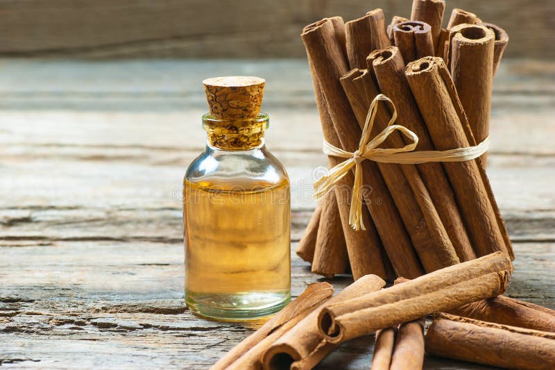Sluit omhoog fles kaneelolie met pijpjes kaneel op houten achtergrond royalty-vrije stock foto Sluit omhoog fles kaneelolie met pijpjes kaneel op houten achtergrond royalty-vrije stock foto