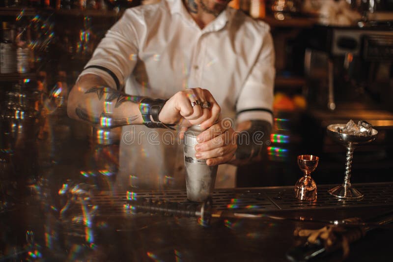 Sluit omhoog foto van een barman die zich bij de tegenholdingsschudbeker bevinden royalty-vrije stock afbeeldingen Sluit omhoog foto van een barman die zich bij de tegenholdingsschudbeker bevinden royalty-vrije stock afbeeldingen
