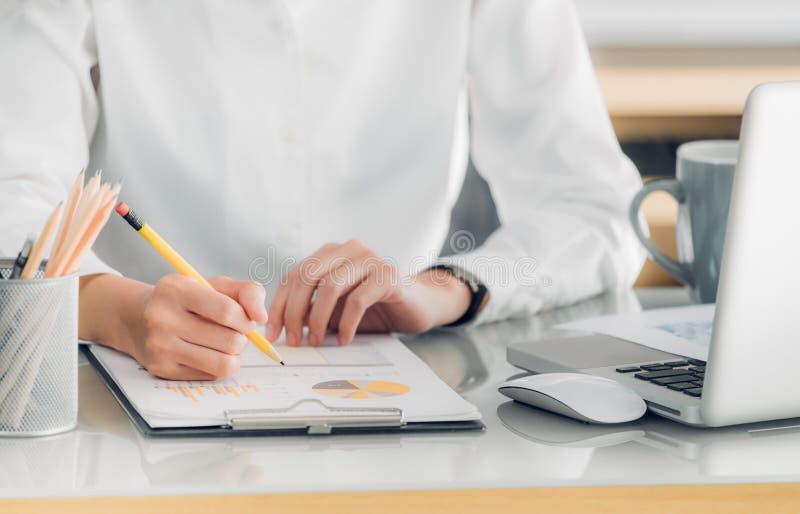 Sluit omhoog hand van onderneemsterhand schrijvend een rapport vooraan o stock afbeelding Sluit omhoog hand van onderneemsterhand schrijvend een rapport vooraan o stock afbeelding