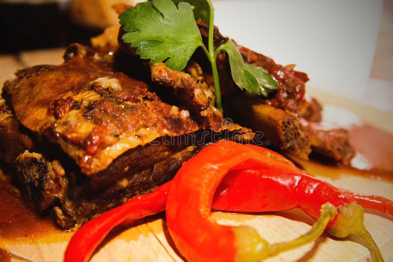 Sluit omhoog mening van de ribben van het barbecuevarkensvlees met saus op oud houten t royalty-vrije stock afbeelding Sluit omhoog mening van de ribben van het barbecuevarkensvlees met saus op oud houten t royalty-vrije stock afbeelding