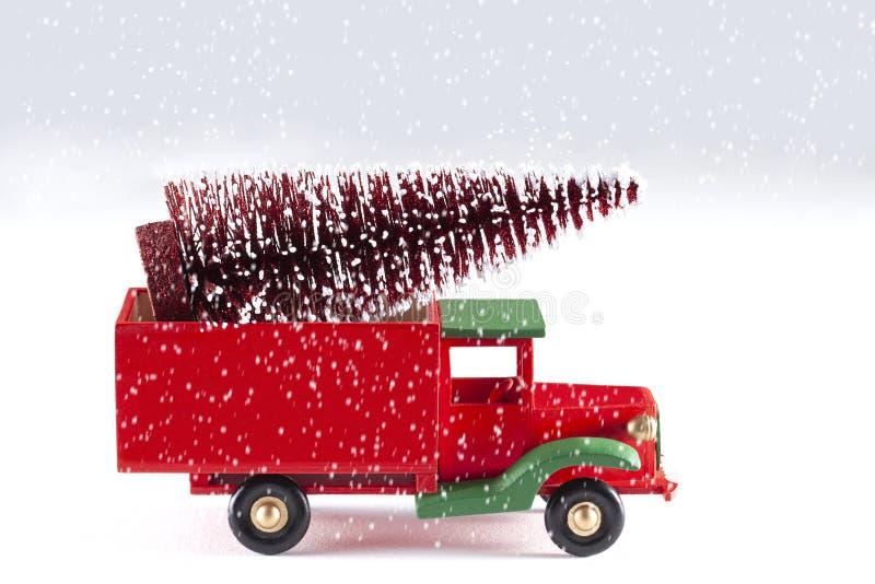 Sluit omhoog op een stuk speelgoed auto met Kerstboom en sneeuwvlokken op witte achtergrond worden geïsoleerd die stock foto Sluit omhoog op een stuk speelgoed auto met Kerstboom en sneeuwvlokken op witte achtergrond worden geïsoleerd die stock foto
