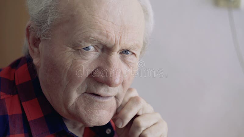 Sluit omhoog portret van de oude mens bekijkt venster met denkt toen glimlachen bij camera