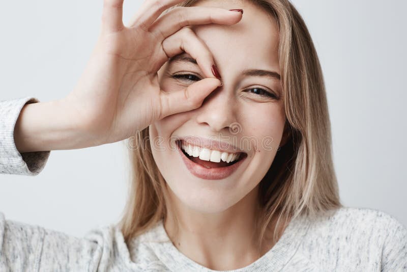Sluit omhoog portret van het mooie blije blonde Kaukasische vrouwelijke glimlachen, het aantonen witte tanden, die de camera beki royalty-vrije stock foto's Sluit omhoog portret van het mooie blije blonde Kaukasische vrouwelijke glimlachen, het aantonen witte tanden, die de camera beki royalty-vrije stock foto's