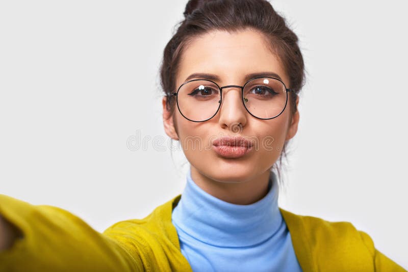 Sluit omhoog studioportret van vrolijke vrij jonge donkerbruine vrouw met mooie schone huid, draagt transparante oogglazen royalty-vrije stock afbeelding Sluit omhoog studioportret van vrolijke vrij jonge donkerbruine vrouw met mooie schone huid, draagt transparante oogglazen royalty-vrije stock afbeelding