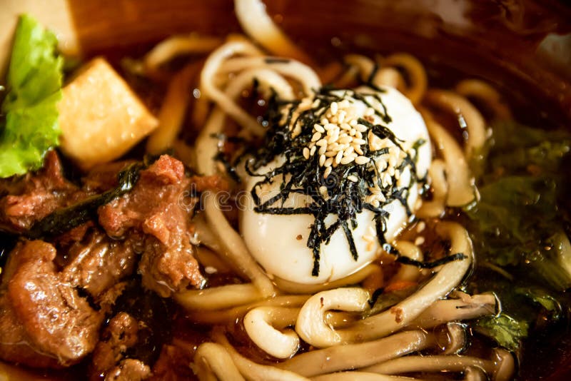 Sluit omhoog traditioneel menu, de noedels van Korea met varkensvleessoep, wit sesambovenste laagje en ei, heerlijke maaltijd stock fotografie Sluit omhoog traditioneel menu, de noedels van Korea met varkensvleessoep, wit sesambovenste laagje en ei, heerlijke maaltijd stock fotografie