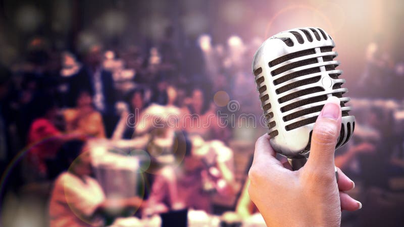 Sluit omhoog uitstekende microfoon in zangerhand het zingen op stadium van de partij van de huwelijksgebeurtenis of commerciële v