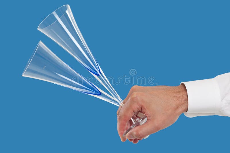 Close up of hand holding champagne flutes in a blue background. Close up of hand holding champagne flutes in a blue background