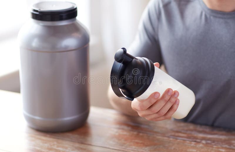 Sluit omhoog van de mens met eiwitschokfles en kruik stock foto Sluit omhoog van de mens met eiwitschokfles en kruik stock foto