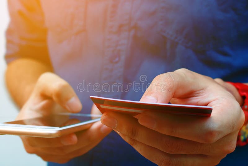 Sluit omhoog van de slimme telefoon van het jonge mensengebruik en holdingscreditcard, s stock fotografie Sluit omhoog van de slimme telefoon van het jonge mensengebruik en holdingscreditcard, s stock fotografie