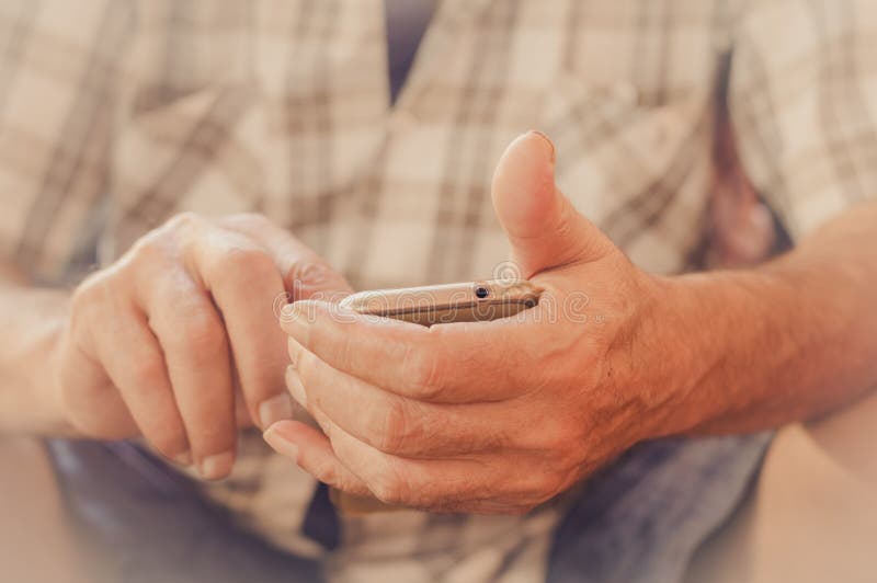 Sluit omhoog van een bejaardehand gebruikend mobiele slimme telefoon royalty-vrije stock afbeeldingen Sluit omhoog van een bejaardehand gebruikend mobiele slimme telefoon royalty-vrije stock afbeeldingen