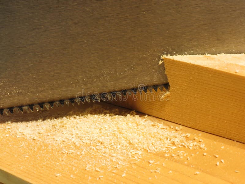 Sluit omhoog van een handzaag snijdend een stuk van hout op het houten werk royalty-vrije stock foto's Sluit omhoog van een handzaag snijdend een stuk van hout op het houten werk royalty-vrije stock foto's