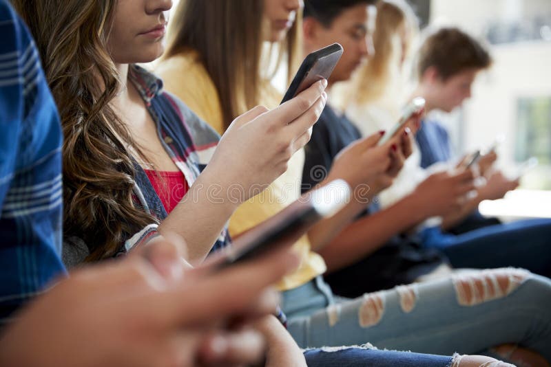 Sluit omhoog van een Lijn van Middelbare schoolstudenten Gebruikend Mobiele Telefoons