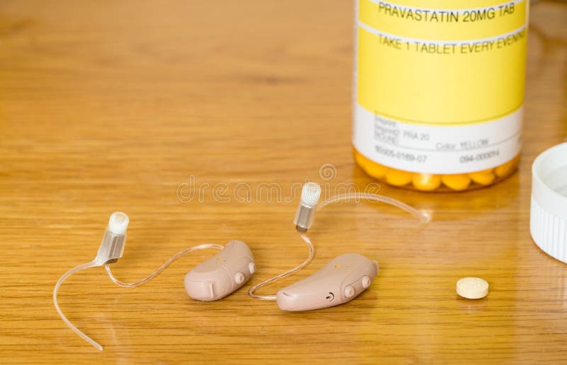 Sluit omhoog van een paar uiterst kleine moderne hoorapparaten met voorschriftdrug royalty-vrije stock foto Sluit omhoog van een paar uiterst kleine moderne hoorapparaten met voorschriftdrug royalty-vrije stock foto