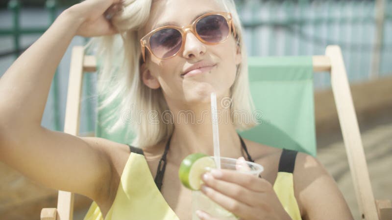 Sluit omhoog van een vrouw die een tropische die mojitococktail drinken met vers fruit door een stro op haar de zomervakantie wor stock fotografie Sluit omhoog van een vrouw die een tropische die mojitococktail drinken met vers fruit door een stro op haar de zomervakantie wor stock fotografie
