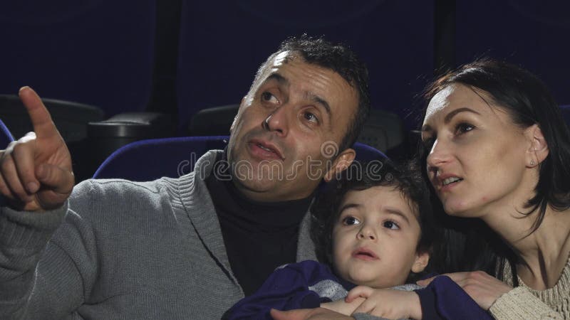 Sluit omhoog van gelukkige het houden van familie het letten op films bij de bioskoop