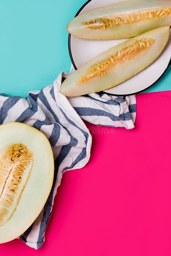 Sluit omhoog van gesneden meloen en plakken van fruit op een kleurenachtergrond stock foto Sluit omhoog van gesneden meloen en plakken van fruit op een kleurenachtergrond stock foto