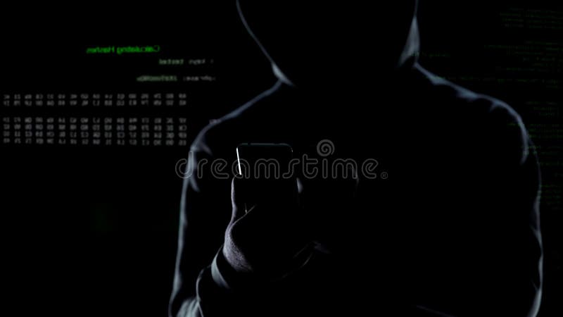 Sluit omhoog van hakker die met een kap cyber aanval op smartphone in werking stellen, lancerend bom stock foto's Sluit omhoog van hakker die met een kap cyber aanval op smartphone in werking stellen, lancerend bom stock foto's