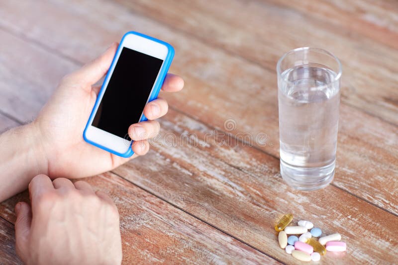Sluit omhoog van handen met smartphone, pillen en water royalty-vrije stock fotografie Sluit omhoog van handen met smartphone, pillen en water royalty-vrije stock fotografie
