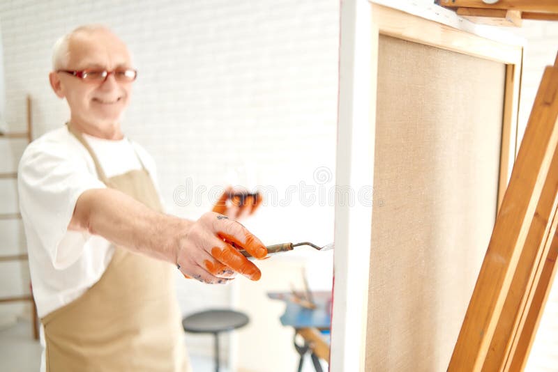 Sluit omhoog van hogere mannelijke schildershand, binnen schilderend laatste slagen royalty-vrije stock foto Sluit omhoog van hogere mannelijke schildershand, binnen schilderend laatste slagen royalty-vrije stock foto
