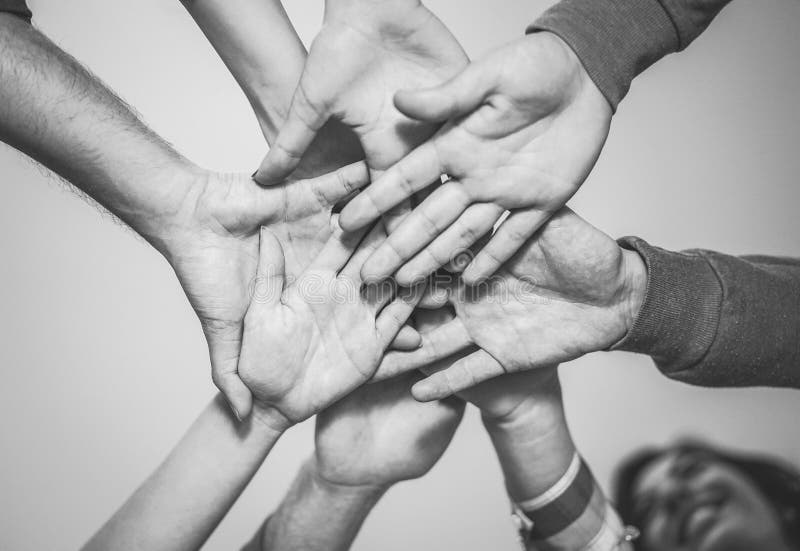 Sluit omhoog van jong groepswerk samenbrengend hun handen voor een nieuwe samenwerking - Vrolijke vrienden die op een plan worden royalty-vrije stock afbeelding Sluit omhoog van jong groepswerk samenbrengend hun handen voor een nieuwe samenwerking - Vrolijke vrienden die op een plan worden royalty-vrije stock afbeelding
