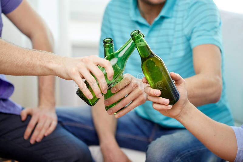 Sluit omhoog van mannelijke vrienden die bier thuis drinken stock foto Sluit omhoog van mannelijke vrienden die bier thuis drinken stock foto