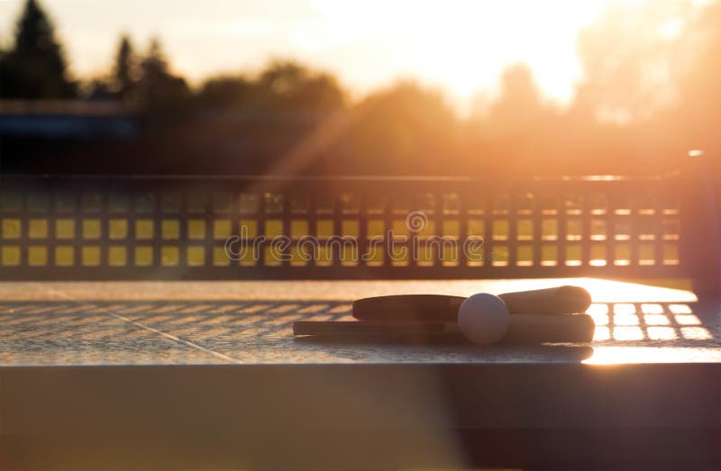 Sluit omhoog van pingpongbal met tennisrackets op de lijst van het steentennis in zonnige lichten, dient het Materiaal voor in op stock foto's Sluit omhoog van pingpongbal met tennisrackets op de lijst van het steentennis in zonnige lichten, dient het Materiaal voor in op stock foto's