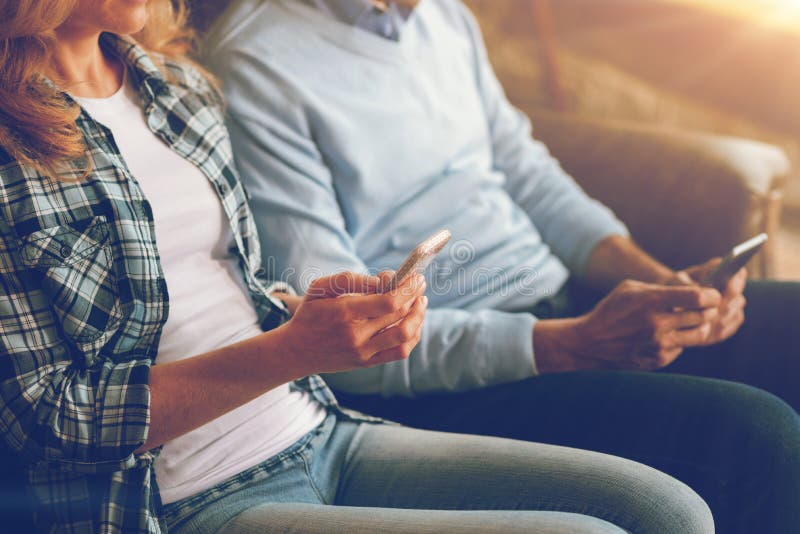 Sluit omhoog van rijp paar gebruikend smartphones stock afbeeldingen Sluit omhoog van rijp paar gebruikend smartphones stock afbeeldingen