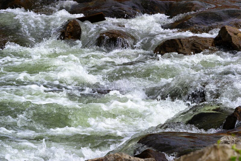 Sluit omhoog van rivierwater die over rotsen draperen stock fotografie Sluit omhoog van rivierwater die over rotsen draperen stock fotografie