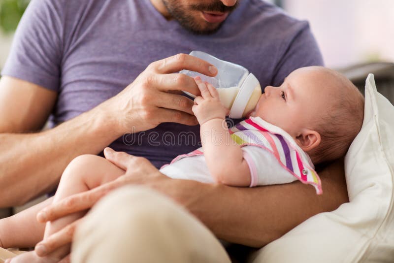 Sluit omhoog van vader voedende baby van fles