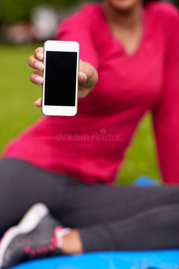 Fitness, people, technology and sport concept - close up of african american woman showing smartphone outdoors. Fitness, people, technology and sport concept - close up of african american woman showing smartphone outdoors