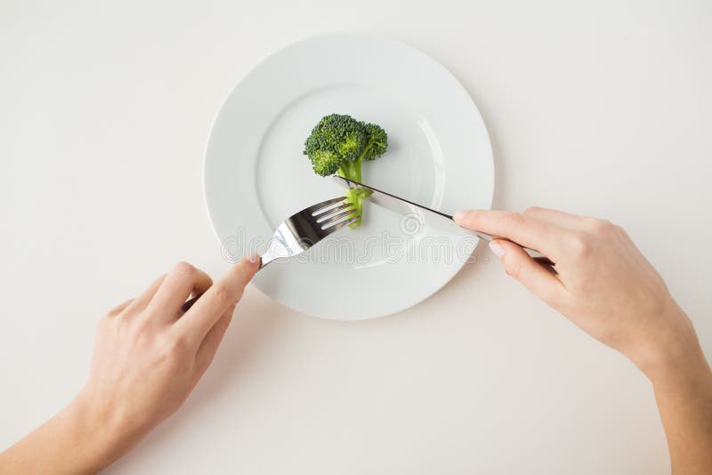 Sluit omhoog van vrouwenhanden etend broccoli stock afbeeldingen Sluit omhoog van vrouwenhanden etend broccoli stock afbeeldingen