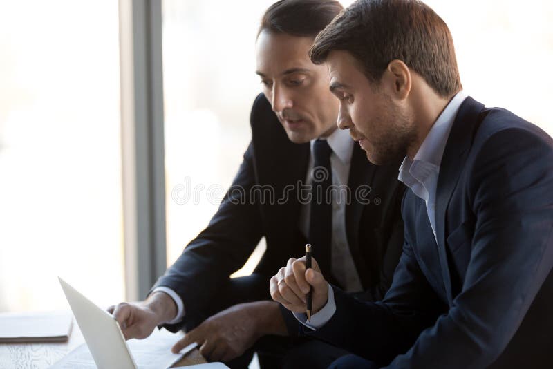 Sluit van ernstige collega's bespreken omhoog project over laptop royalty-vrije stock afbeelding Sluit van ernstige collega's bespreken omhoog project over laptop royalty-vrije stock afbeelding