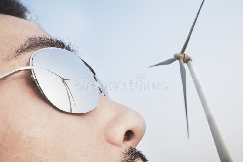 Sluit van jong bemant omhoog gezicht met de bezinning van de windturbine in zijn zonnebril royalty-vrije stock foto's Sluit van jong bemant omhoog gezicht met de bezinning van de windturbine in zijn zonnebril royalty-vrije stock foto's