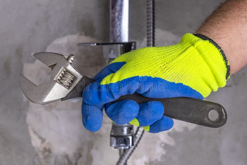 Close-up. the master clamps the nut. fasten the tap to the wall. Close-up. the master clamps the nut. fasten the tap to the wall.