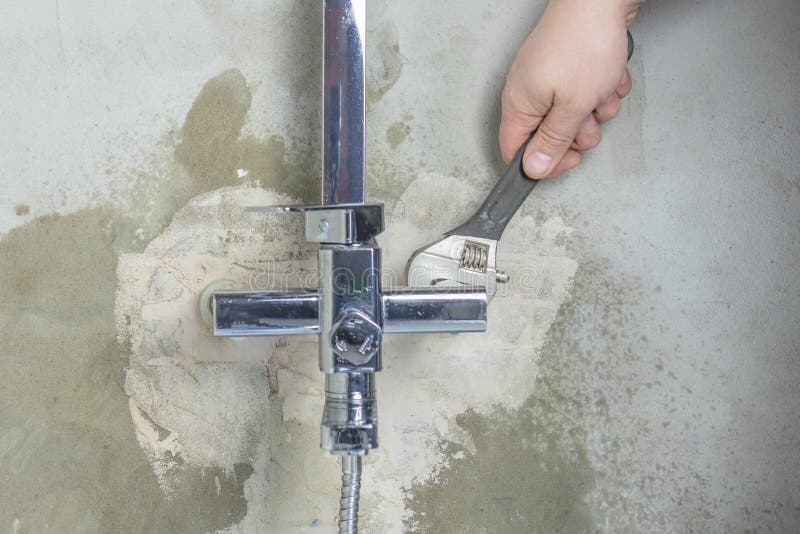 Close-up. the master clamps the nut. fasten the tap to the wall. Close-up. the master clamps the nut. fasten the tap to the wall.