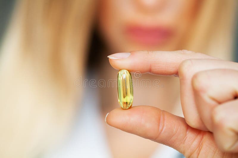 Sluiting van de vrouwelijke arts die de pil vasthoudt stock foto's